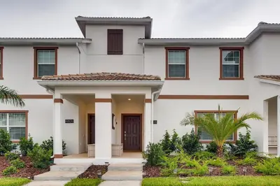 a white house with a front door at 4808 LL Magical 4BR Disney Townhome Pool in Kissimmee