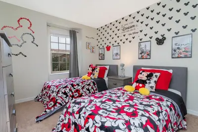 two beds in a bedroom with red and black at 8843 GC Windsor at Westside Luxury 5 BR Townhome in Kissimmee