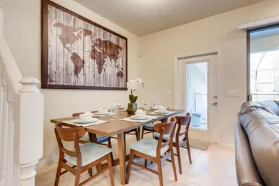 a dining room with a table and chairs at 8843 GC Windsor at Westside Luxury 5 BR Townhome in Kissimmee