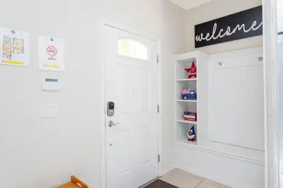 a white hallway with a white door and shelves at 8843 GC Windsor at Westside Luxury 5 BR Townhome in Kissimmee