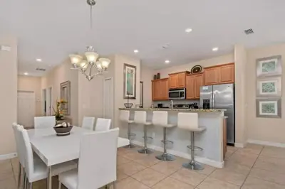 a dining room and kitchen with a white table and chairs at 2947BPD-SVH in Kissimmee