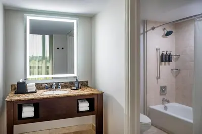 a bathroom with a sink and a toilet and a mirror at Sheraton Orlando North in Orlando