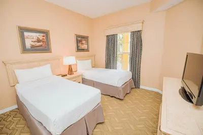 a hotel room with two beds and a television at WorldQuest Orlando Resort in Orlando