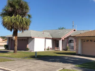 a house with a palm tree in front of it at Laguna Villas in Kissimmee