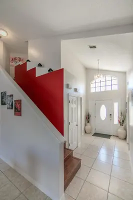 a hallway with a red staircase in a home at Mickey's Lake Villa 2 in Orlando
