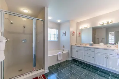 a bathroom with a shower and a sink and a tub at Mickey's Lake Villa 2 in Orlando