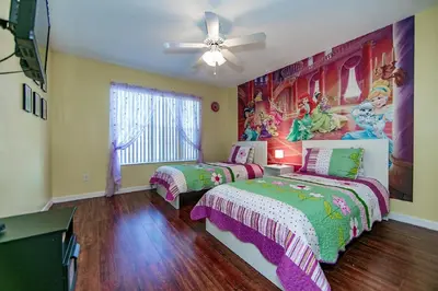 a bedroom with two beds and a painting on the wall at Mickey's Lake Villa 2 in Orlando