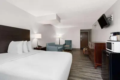 a hotel room with a bed and a tv at Baymont by Wyndham Orlando-International Dr-Universal Blvd in Orlando
