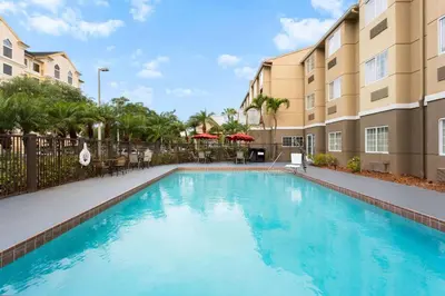 a swimming pool in front of a building at Baymont by Wyndham Orlando-International Dr-Universal Blvd in Orlando