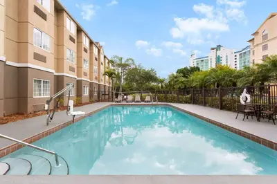 a swimming pool at a apartment complex with a building at Baymont by Wyndham Orlando-International Dr-Universal Blvd in Orlando