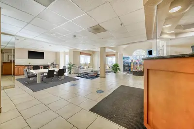 a large living room with a table and a dining room at Baymont by Wyndham Orlando-International Dr-Universal Blvd in Orlando