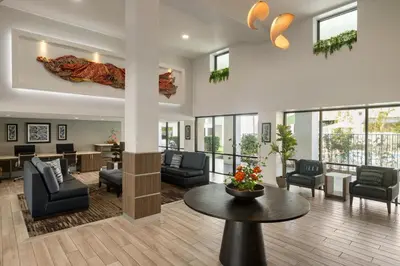 a lobby with couches and chairs and a table at Mai Hana Hotel and Suites I Drive-Theme Parks in Orlando