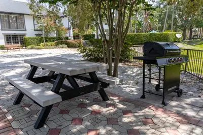 a picnic table and a grill and a picnic bench at Legacy Vacation Resorts - Disney and Lake Buena Vista in Orlando