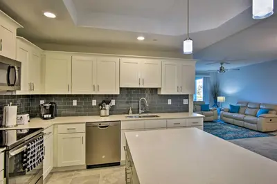 a kitchen with white cabinets and a living room at Kissimmee Condo with Resort-Style Amenities! in Kissimmee