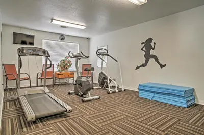 a gym with exercise equipment and a mural of a woman at Close to Disney and Resort Perks Kissimmee Condo in Kissimmee