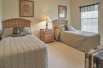 a bedroom with two beds and a lamp on a night stand at 4 Mi to Disney Kissimmee Group Getaway in Orlando
