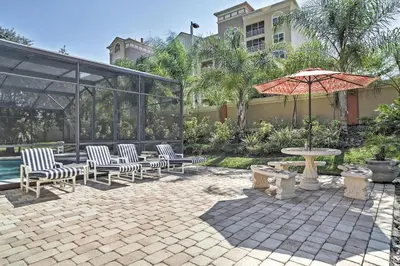 a patio with chairs and a table and an umbrella at 4 Mi to Disney Kissimmee Group Getaway in Orlando