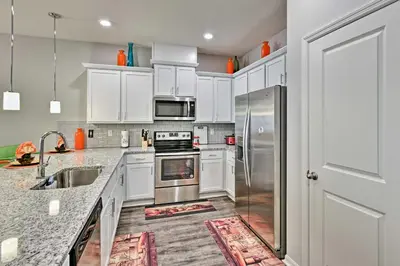 a kitchen with white cabinets and stainless steel appliances at Theme Park Retreat with 5-Star Amenities - By Disney in Kissimmee