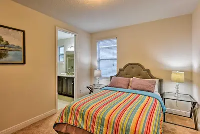a bedroom with a bed with a colorful bedspread at 5 Mi to Disney Oasis with Pool and Patio in Orlando