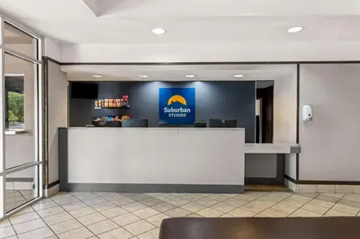 a lobby with a counter with a sign on the wall at Suburban Studios Orlando - Ocoee-Winter Garden in Orlando