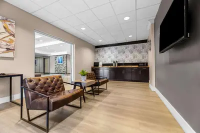 a waiting room with chairs and a flat screen tv at Suburban Studios Orlando - Ocoee-Winter Garden in Orlando