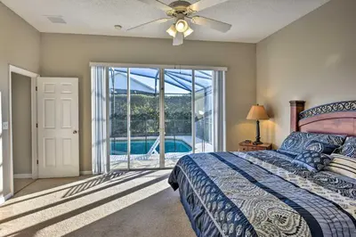 a bedroom with a bed with a ceiling fan at 10 Mi to Disney Resort Home with Pool and Spa in Orlando