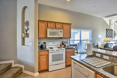 a kitchen with a stove and a microwave at 10 Mi to Disney Resort Home with Pool and Spa in Orlando