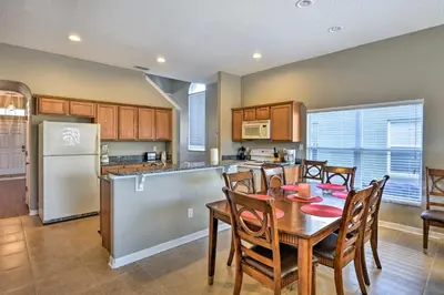 a kitchen with a table and chairs and a refrigerator at 10 Mi to Disney Resort Home with Pool and Spa in Orlando