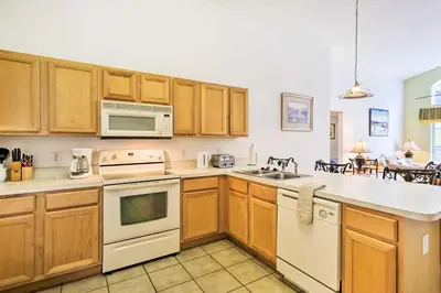 a kitchen with wooden cabinets and white appliances at Retreat with Pool 25 Mi to Disney in Kissimmee