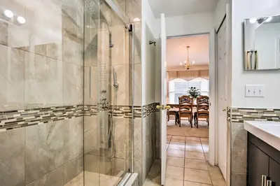 a bathroom with a shower and a dining room at Retreat with Pool 25 Mi to Disney in Kissimmee