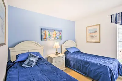a bedroom with two beds with blue sheets and a night stand at Retreat with Pool 25 Mi to Disney in Kissimmee