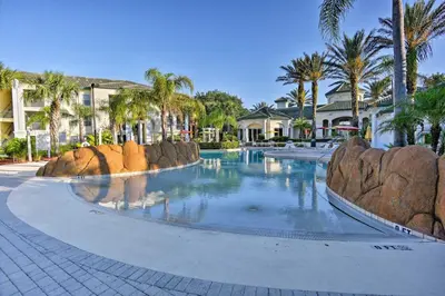 a swimming pool at a resort with palm trees at Lovely Resort Condo Near Disney, Golf and Dining! in Kissimmee