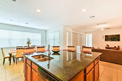 a kitchen with a table and a dining room at Home with Private Pool and Spa 8 Mi to Disney in Kissimmee