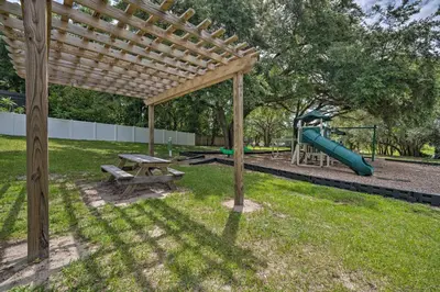 a wooden pergola with a picnic table and a playground at Pet-Friendly Apopka Home 30 Mi to WDW! in Orlando