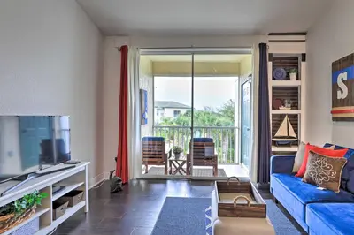 a living room with a blue couch and a tv at Resort-Style Condo with Pool 6 Mi to Magic Kingdom in Kissimmee