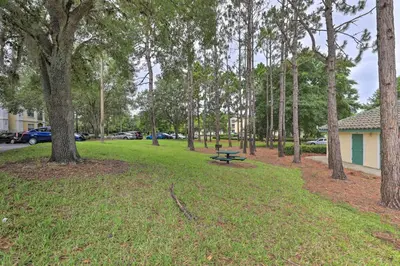 a park with a picnic table in the grass with trees at Resort-Style Condo with Pool 6 Mi to Magic Kingdom in Kissimmee