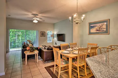 a dining room and living room with a table and chairs at 5 Mi to Disney Emerald Island Resort Condo! in Kissimmee