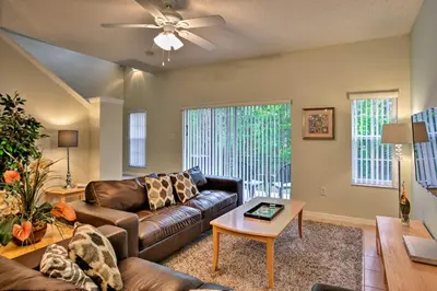 a living room with a couch and a table at 5 Mi to Disney Emerald Island Resort Condo! in Kissimmee