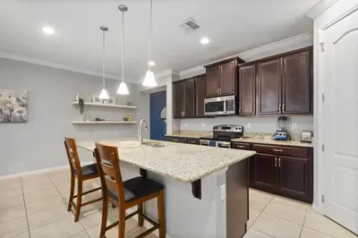 a kitchen with wooden cabinets and a counter top at 4 Mi to Dtwn Home with Pool Access in Sanford in Sanford