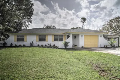 a white house with a yellow garage at Spacious Central Florida Home Family Friendly! in Orlando
