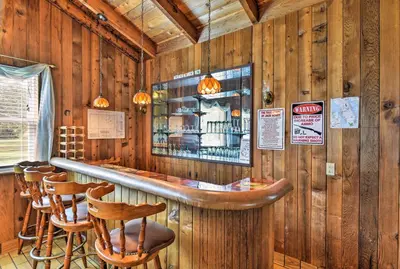 a bar in a restaurant with wooden walls and stools at Sandford Vacation Rental Near Airport and Lake! in Sanford