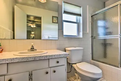 a bathroom with a toilet and a sink and a mirror at Sandford Vacation Rental Near Airport and Lake! in Sanford