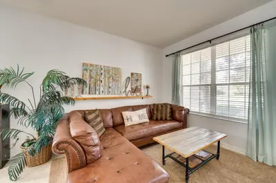 a living room with a brown leather couch and a table at Spacious Home in Gated Resort, 2 Mi to Disney! in Orlando