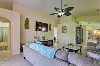 a living room with a couch and a tv at 5 Mi to Disney Parks Kissimmee Home with Game Room in Kissimmee