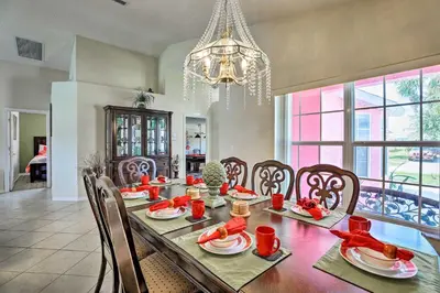 a dining room with a table and chairs and a chandelier at 5 Mi to Disney Parks Kissimmee Home with Game Room in Kissimmee