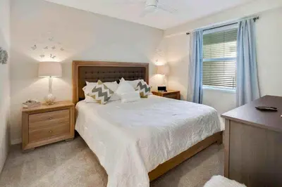 a bedroom with a large bed and a window at Lovely 2BR Codo with 2Clubhouses & Kids Splash Pad in Kissimmee
