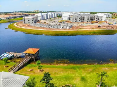 an aerial view of a building next to a body of water at Lovely 2BR Codo with 2Clubhouses & Kids Splash Pad in Kissimmee