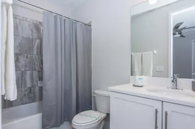 a bathroom with a toilet and a sink and a shower at Amazing Home w a Private Pool in Orlando