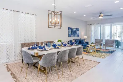a dining room table with chairs and a living room at Amazing Home w a Private Pool in Orlando