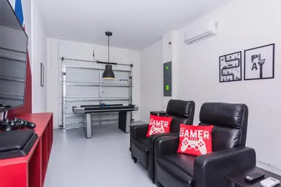 a living room with a couch and a ping pong table at Gorgeous 5 Beds Home with Game Room and Pool in Kissimmee